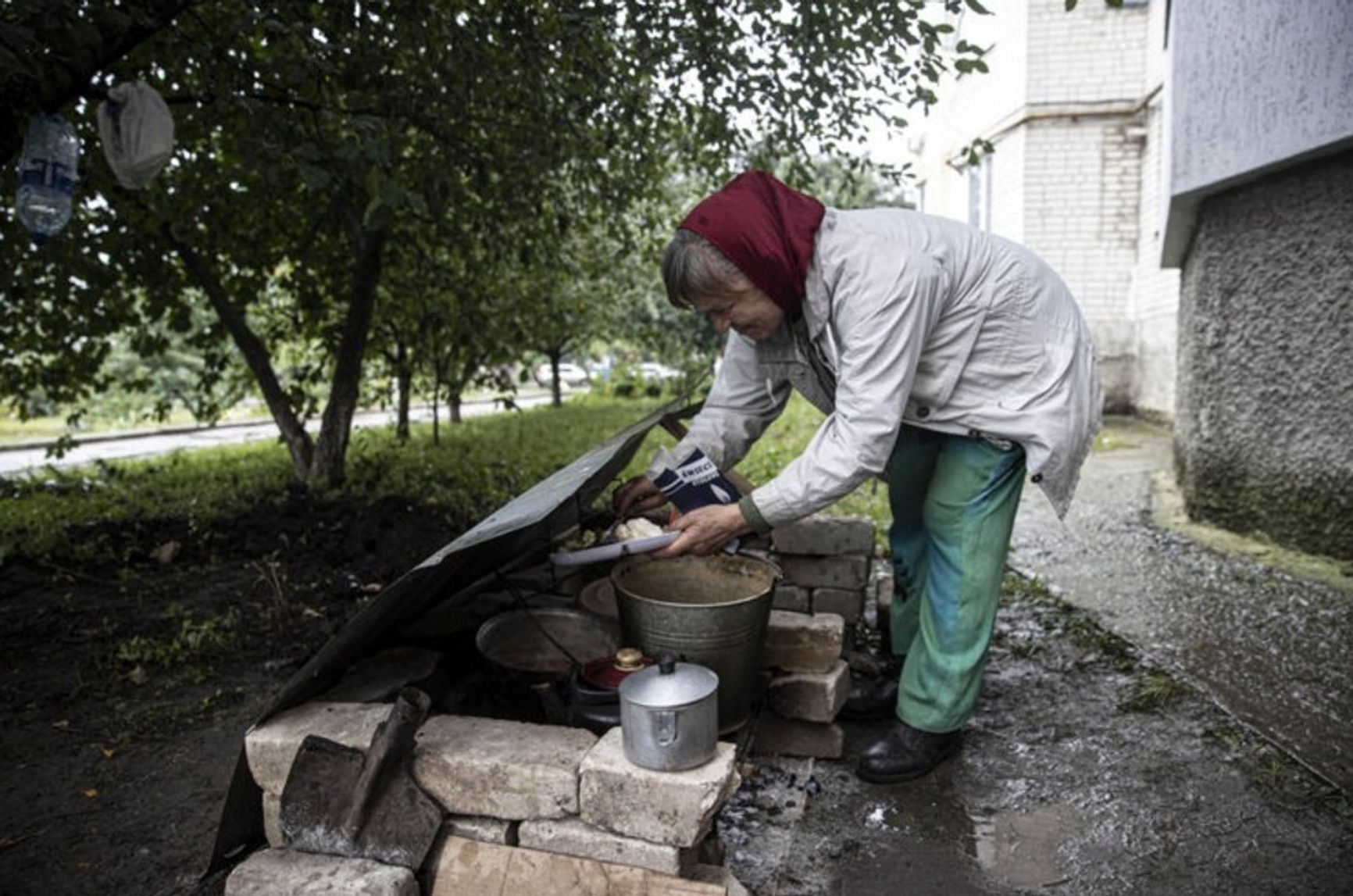 Жительница Купянска готовит еду у подъезда многоэтажки